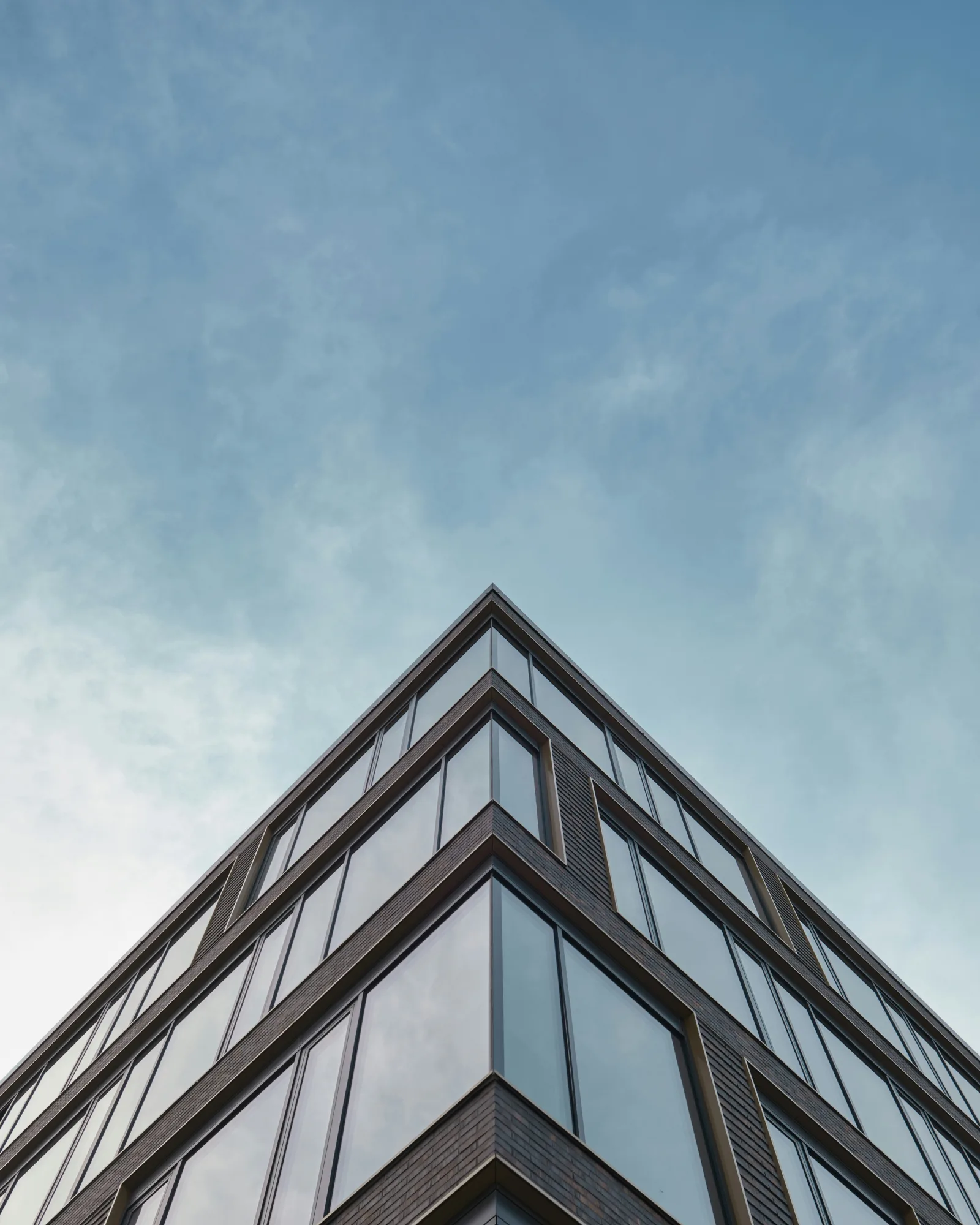 Immeuble contemporain aux façades vitrées et menuiseries sombres