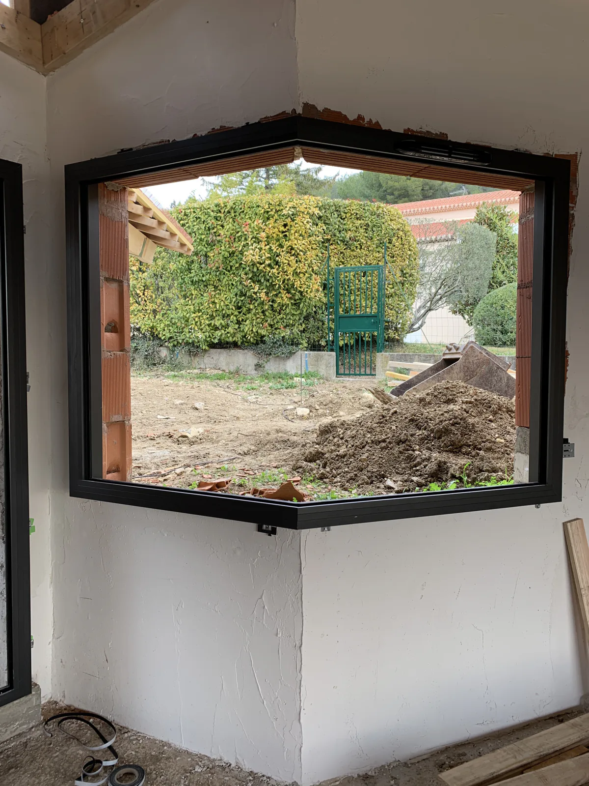 Menuiserie aluminium d’angle intégrée dans une maçonnerie en cours de travaux